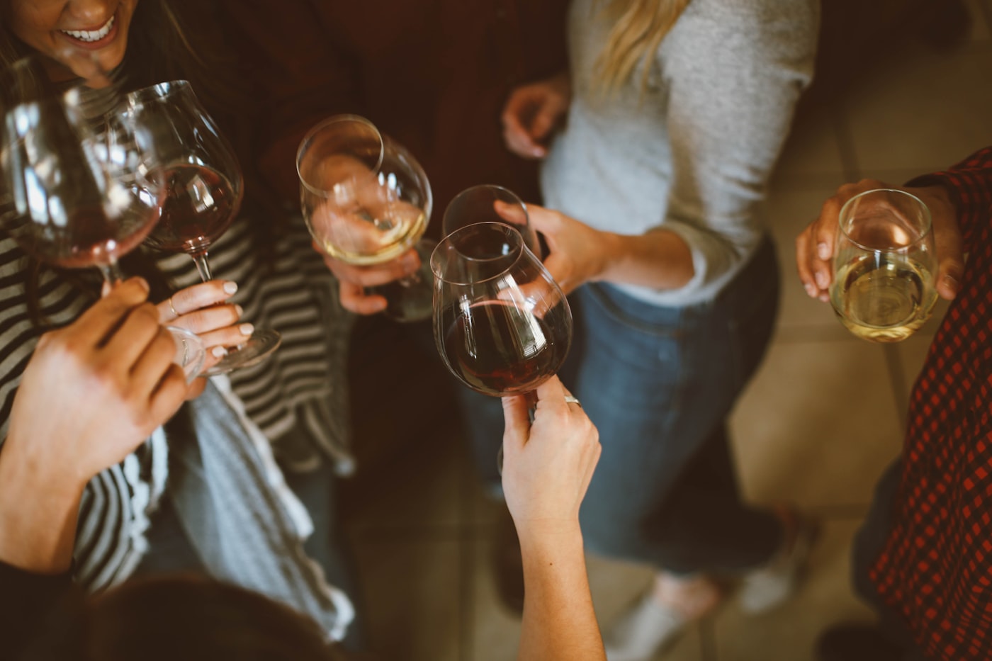 Friends toasting drinks together during a BYOB candle-making night at Candle De Lite