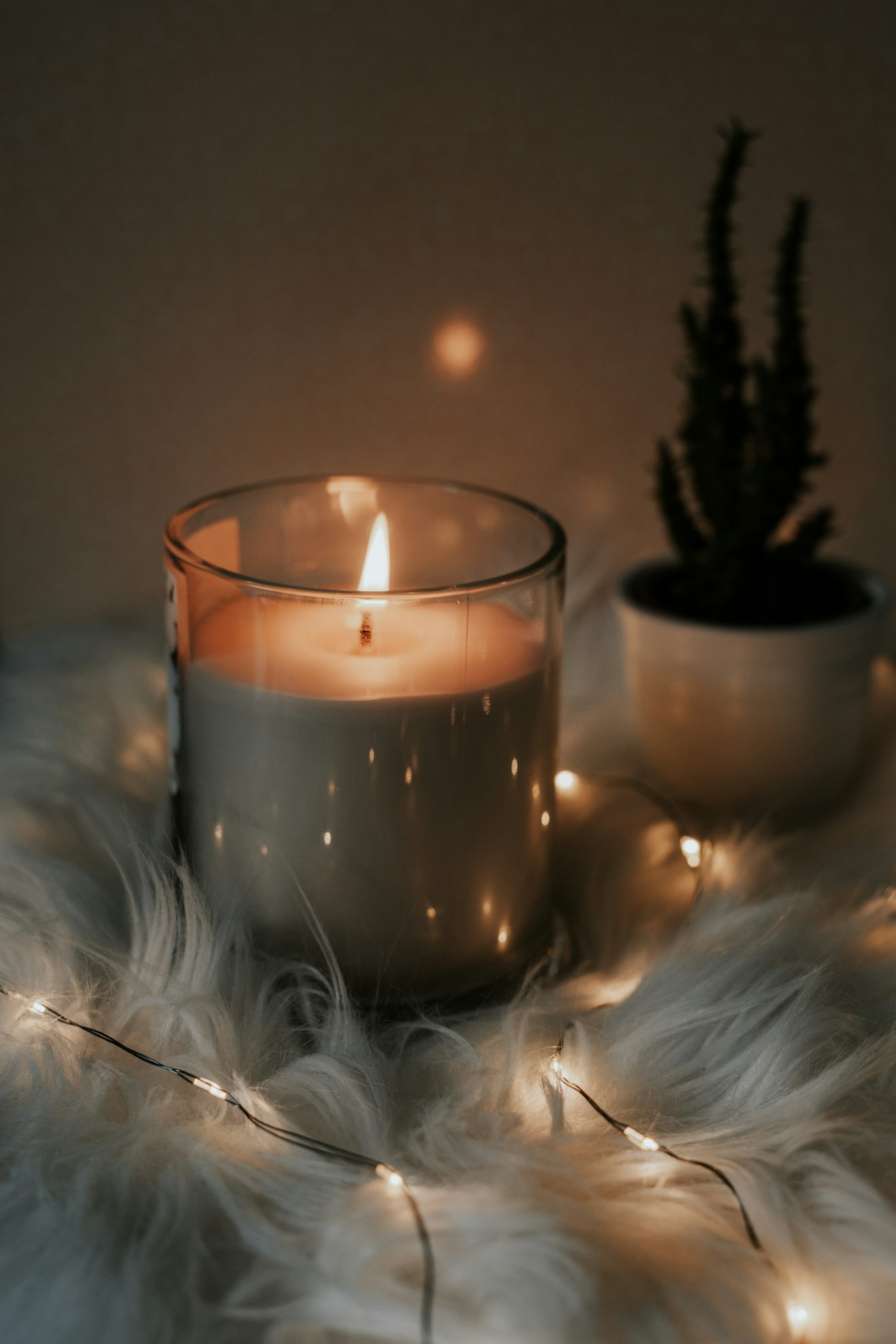 A glowing handmade candle in a glass vessel